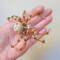 Handmade wire spider ornament in gold, cream, and honey-toned beads on a neutral background